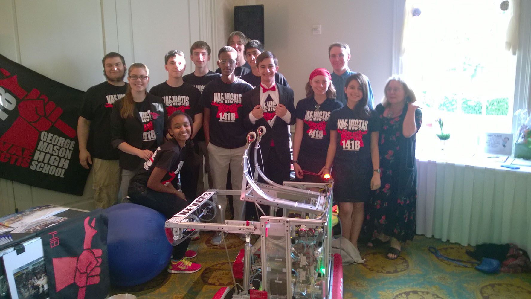 The team posing behind the robot.