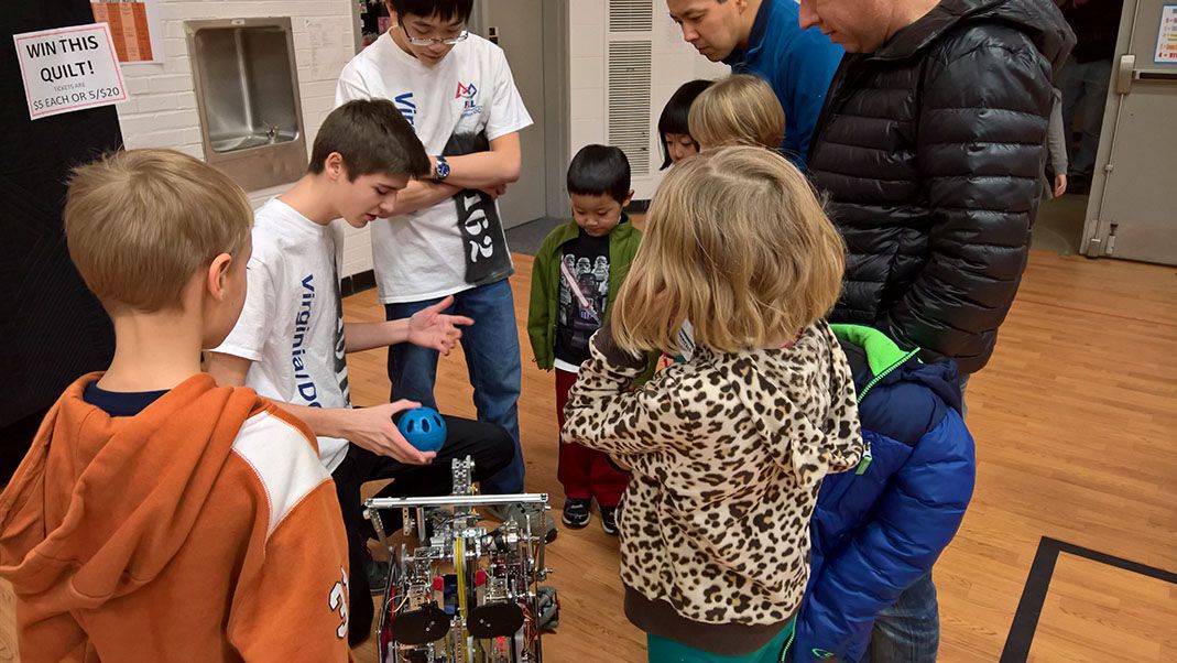 The team showing off a robot to children.