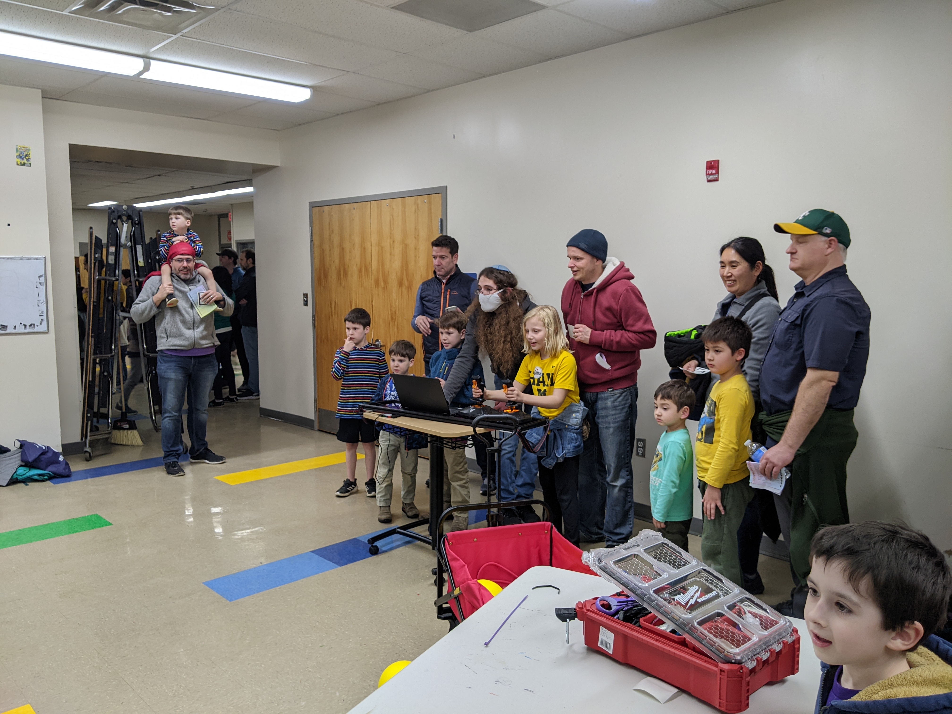 A team member helping a child drive the robot.