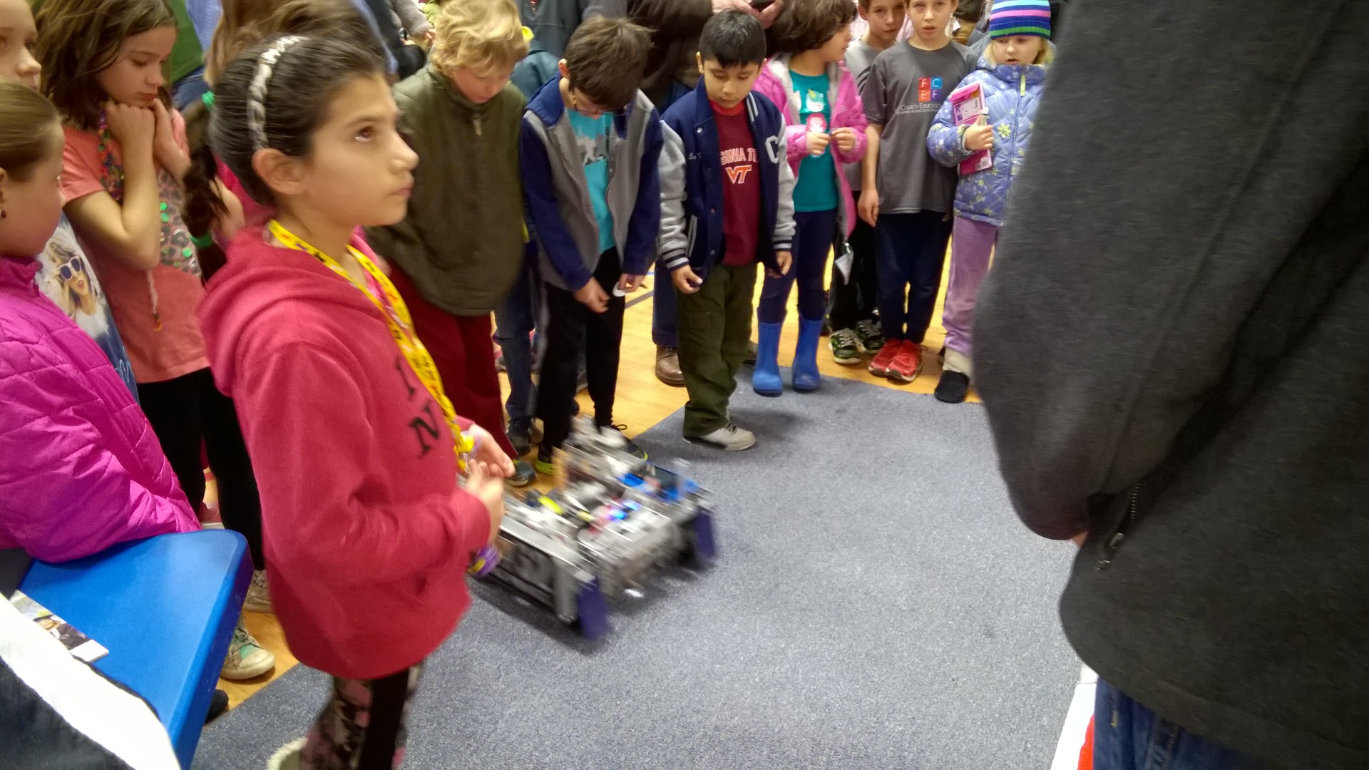 A crowd of children around the robot.
