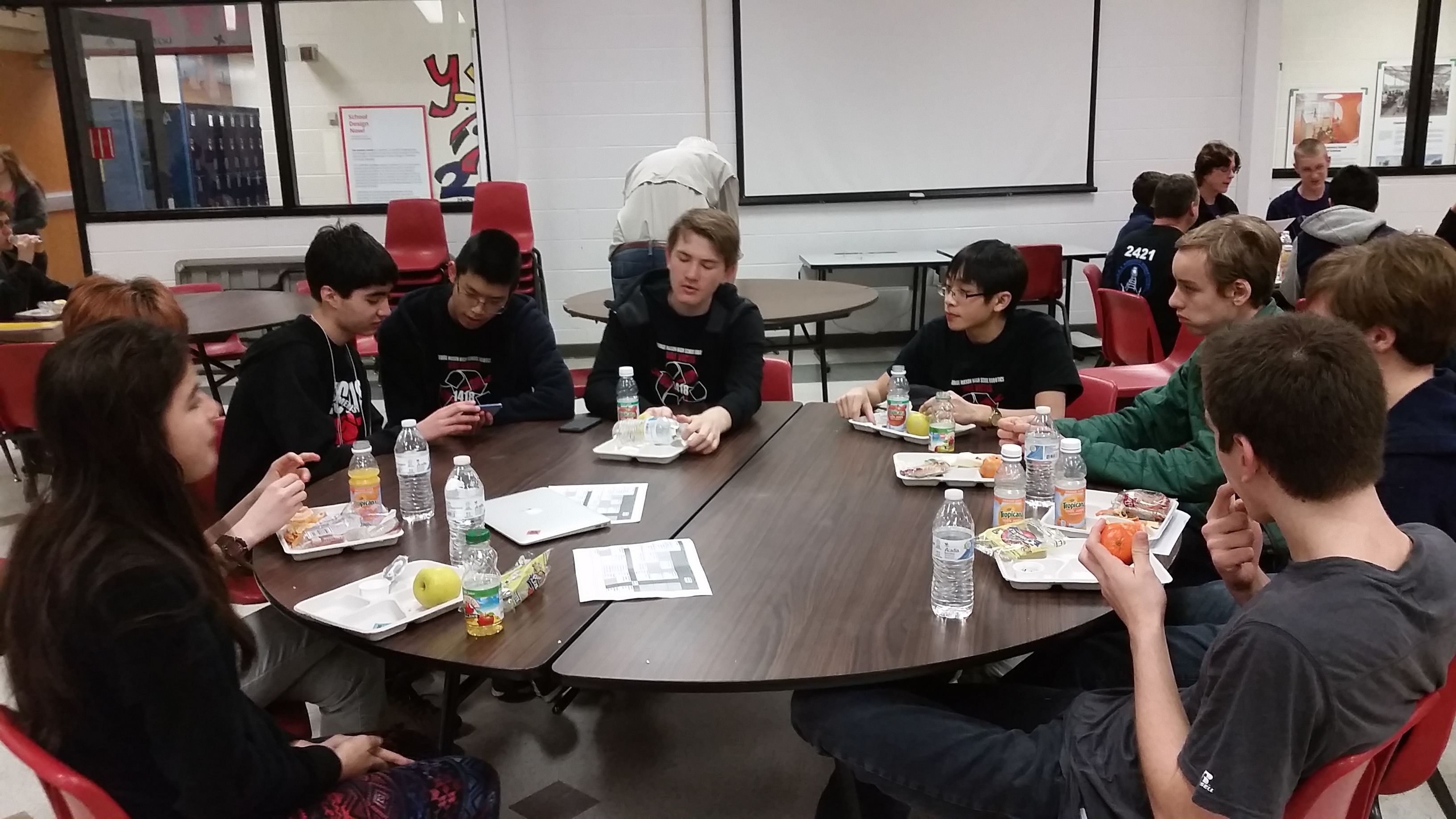 Students attending a 2015 workshop at a brown table.