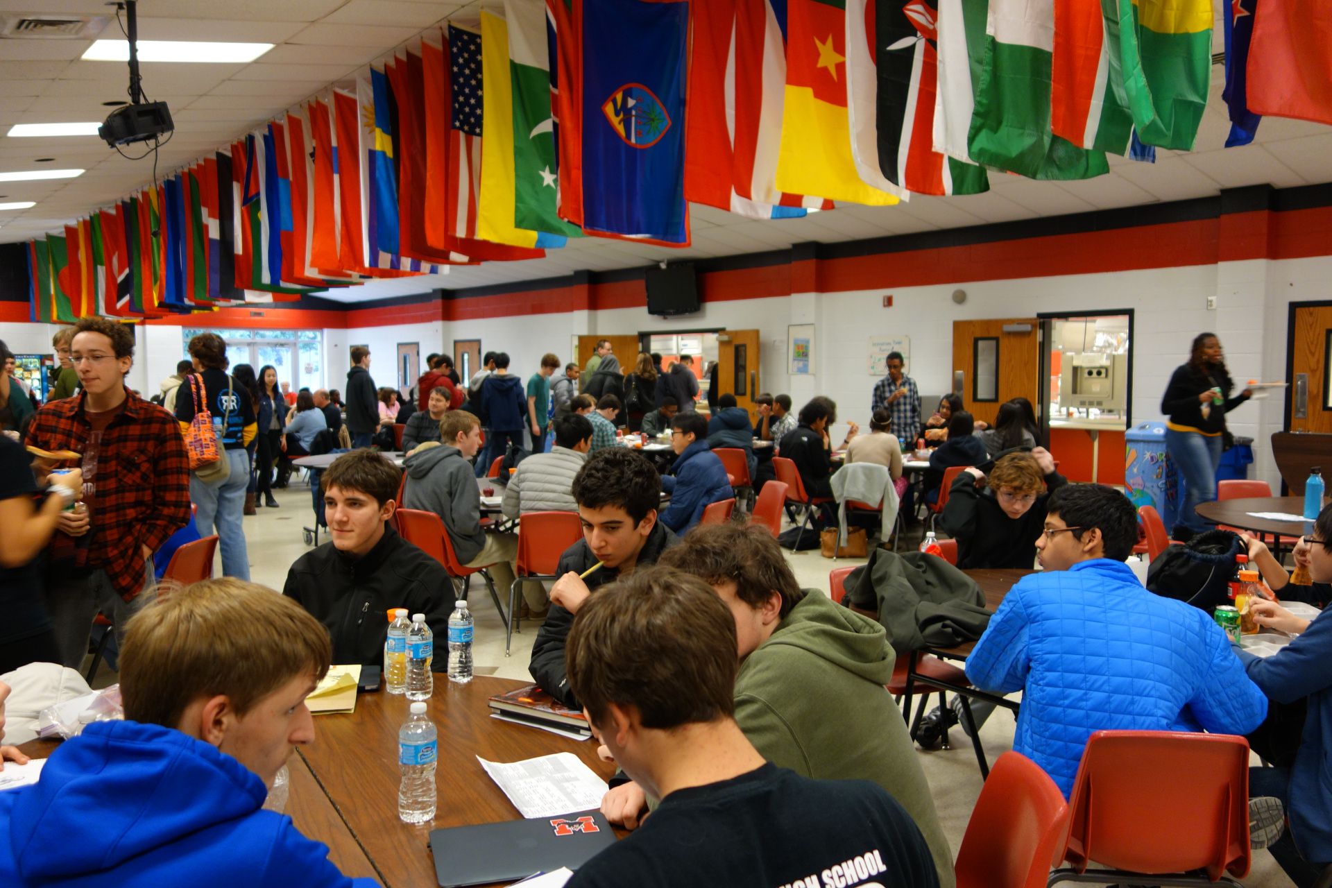 Students attending a 2015 workshop in the cafeteria with national flags lining the ceiling.