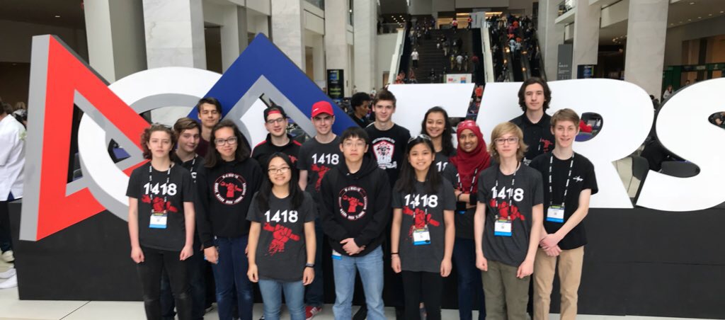 The team at the 2018 FIRST World Championships, in front of the FIRST Logo at the Cobo Center in Detroit.