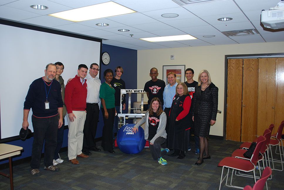 The team and others posing with a catapult ball.