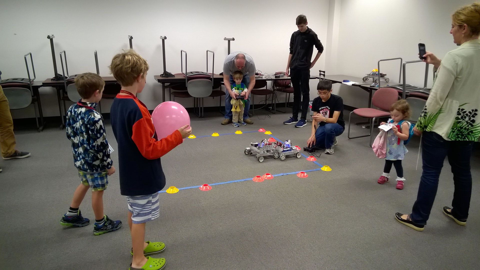 Children playing with a small robot.