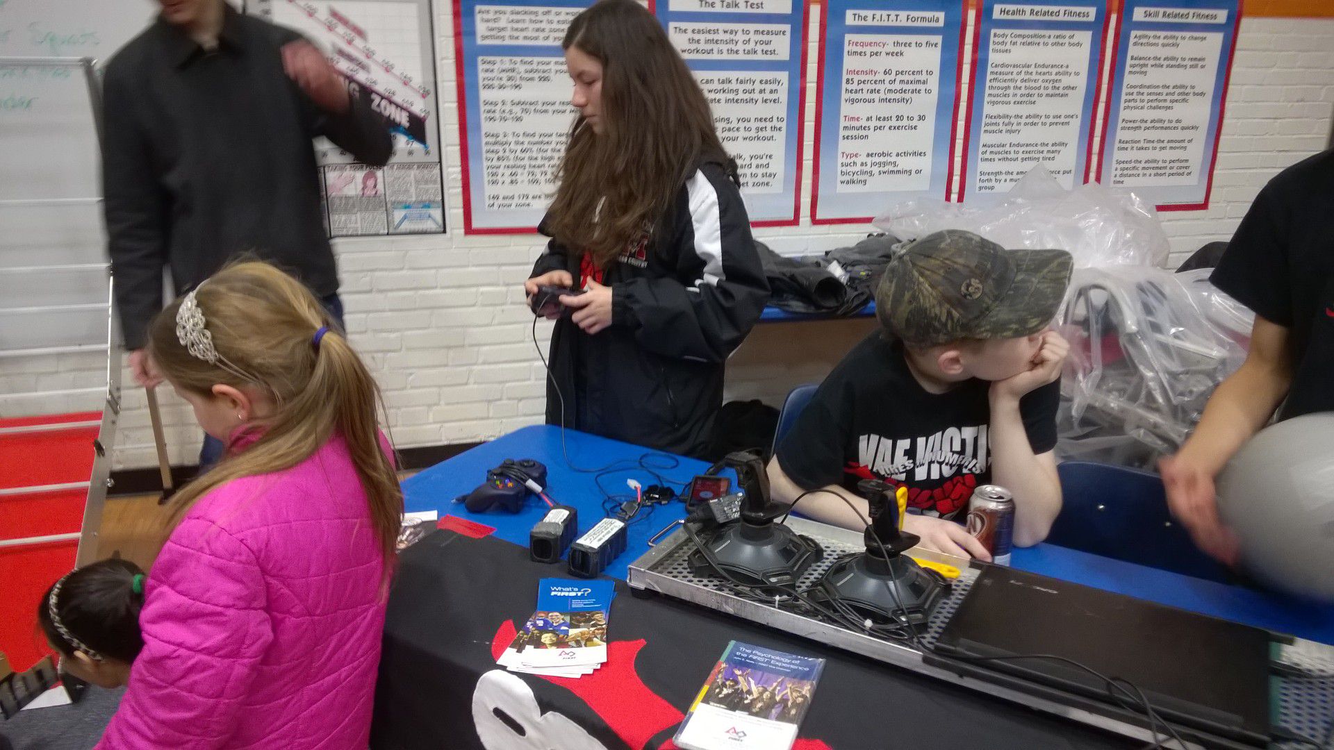 A team member waiting in front of robot controls.