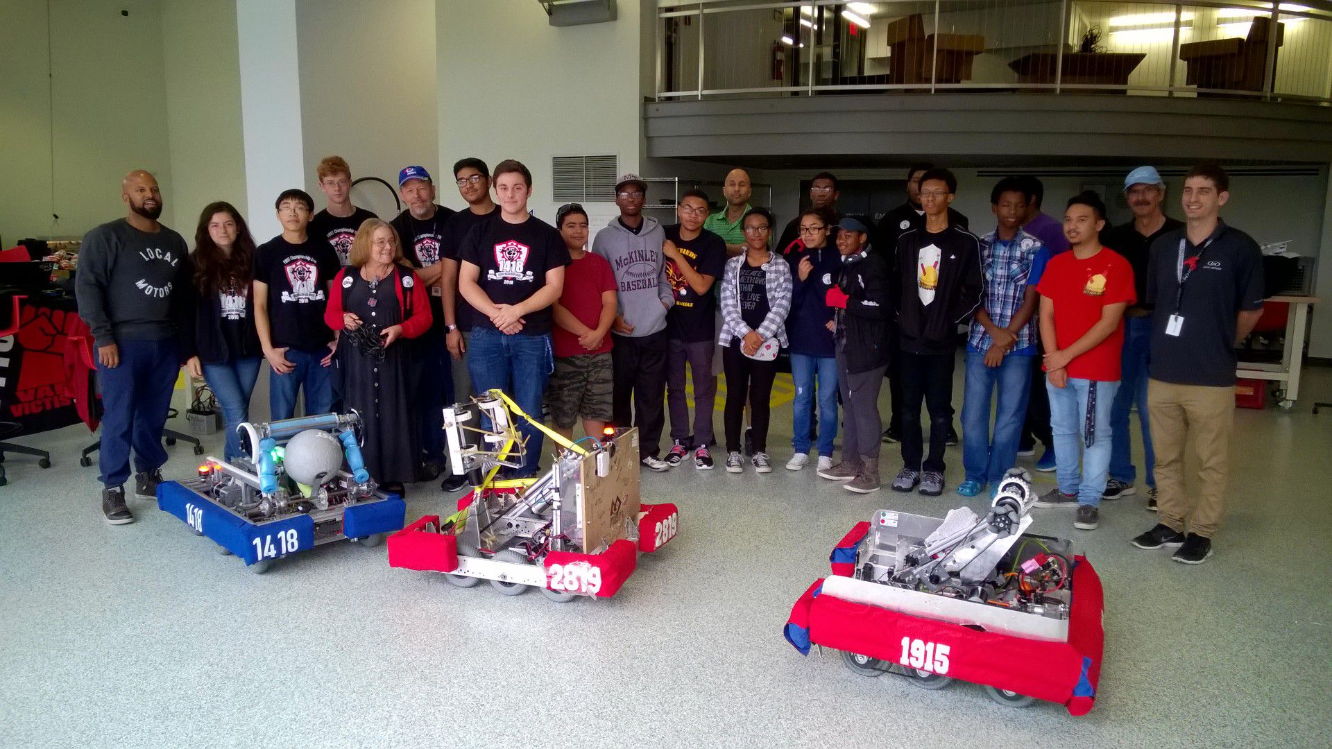 FRC Teams 1418, 1915, and 2819 posing behind their robots.