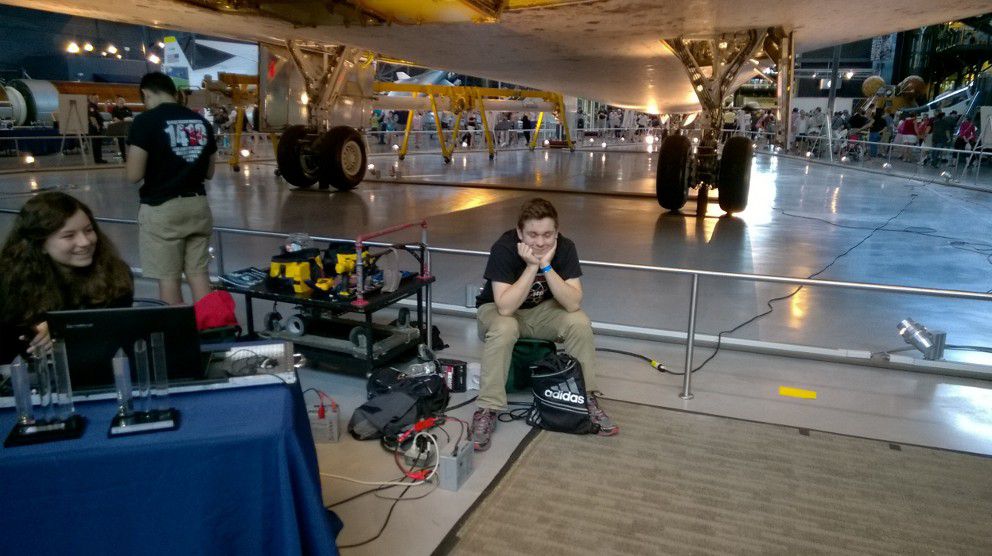 A team member sitting down on a stool.